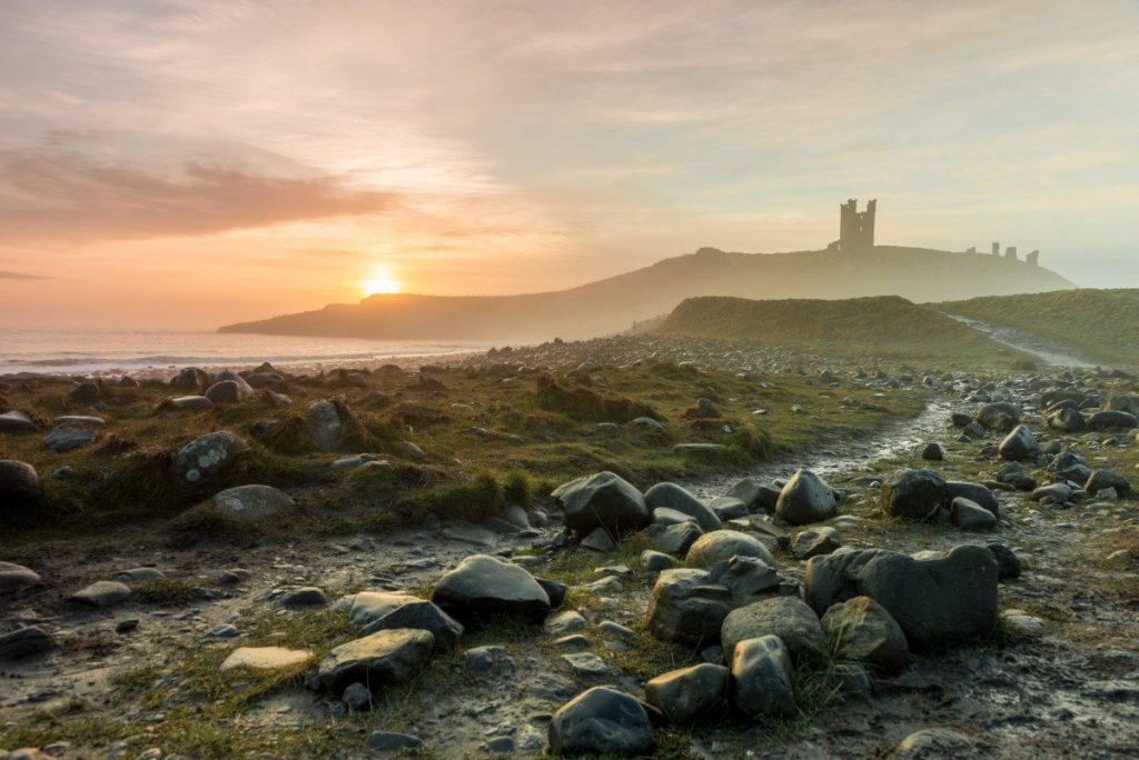 Hrad Dunstanburgh v ranním oparu.