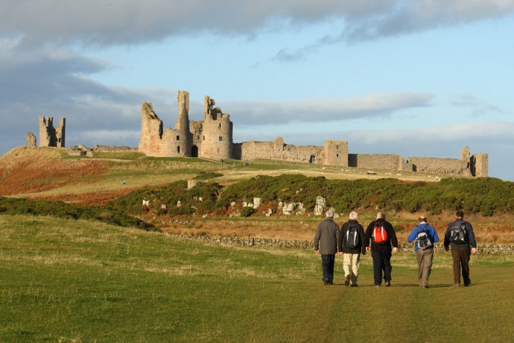 Turisté si užívají cestu ke středověkému hradu Dunstanburgh.