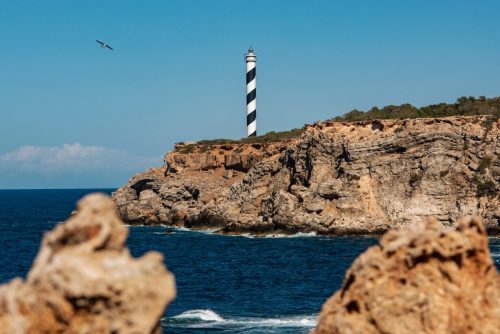Maják Punta Moscarter na skalnatém severním pobřeží ostrova Ibiza.