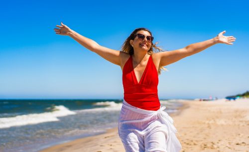 Žena užívající si pobyt na písečné pláži
