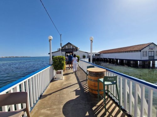 Stylová restaurace vystavěná na mole nad klidnou hladinou Mar Menoru