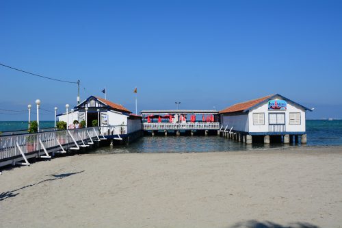 Stylová restaurace vystavěná na mole nad klidnou hladinou Mar Menoru