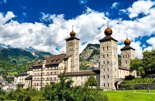 Věže zámku Stockalper Schloss se zvedají pod alpskými štíty