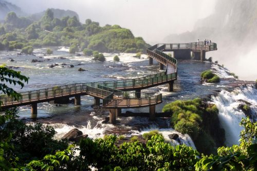 Krásný výhled na pěší stezku přes zelené deštné pralesní vodopády v Iguazu - hranice Brazílie a Argentiny
