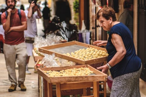 Poklady italské Apulie - dámy připravující domácí těstoviny orecchiette v ulicích Bari