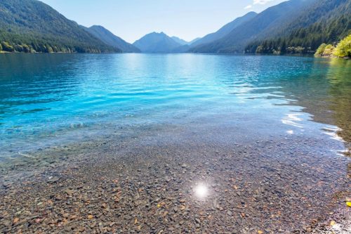Lake Crescent je hluboké ledovcové jezero s křišťálově čistou, sytě modrou vodou, obklopené horskými lesy