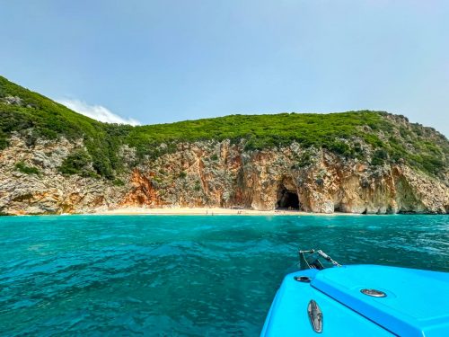 Z lodi budete mít příležitost kochat se pobřežím s přírodními plážemi a dramatickými skalami - na fotografii odlehlá pláž u jeskyně Pigeons nedaleko městečka Himare