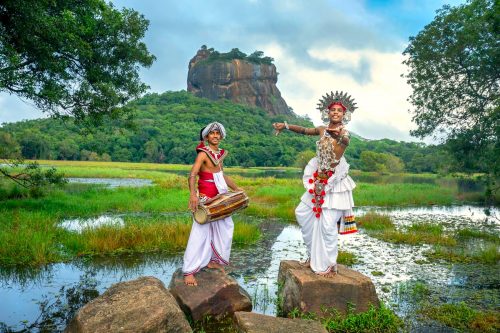Tanečníci na Srí Lance v tradičních kostýmech, v pozadí hora Sigiriya