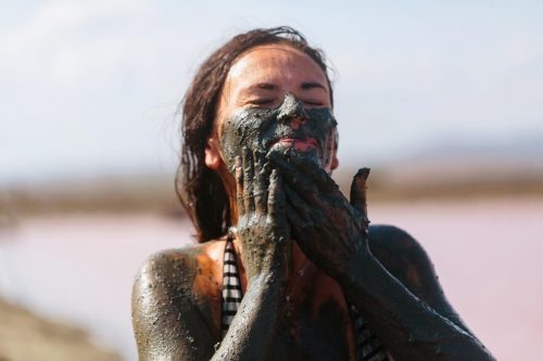 Žena, která má kůži pokrytou léčivým bahnem