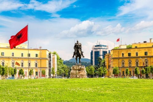 Skanderbegovo náměstí s jeho jezdeckou sochou a vlající vlajko Albánie.