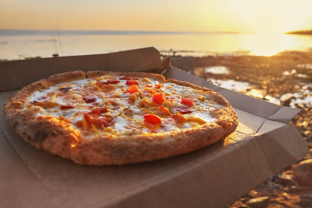 Italská pizza s mozzarellou a rajčaty podávaná u moře v Kampánii.