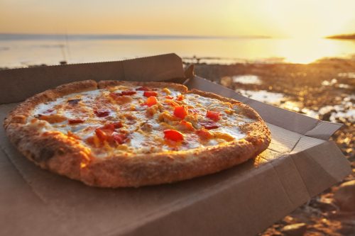 Italská pizza s mozzarellou a rajčaty podávaná u moře v Kampánii.