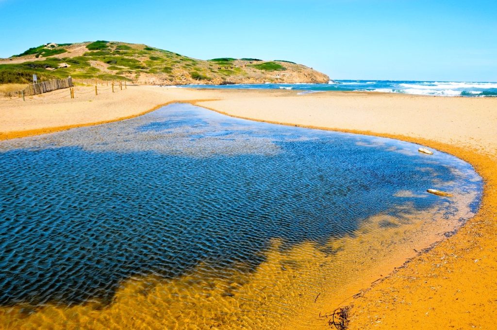 Přírodní písečná pláž Cala Algaiarens na severním pobřeží Menorky.